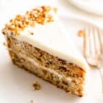 A slice of hummingbird cake on a white plate.