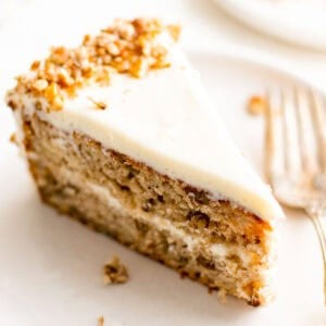 A slice of hummingbird cake on a white plate.