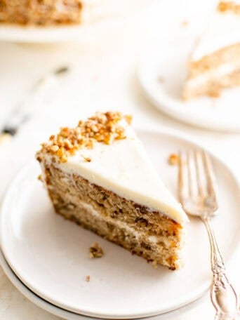 A slice of hummingbird cake on a white plate.