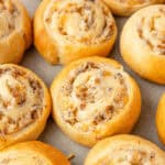 A close up of sausage pinwheels on a cookie sheet.