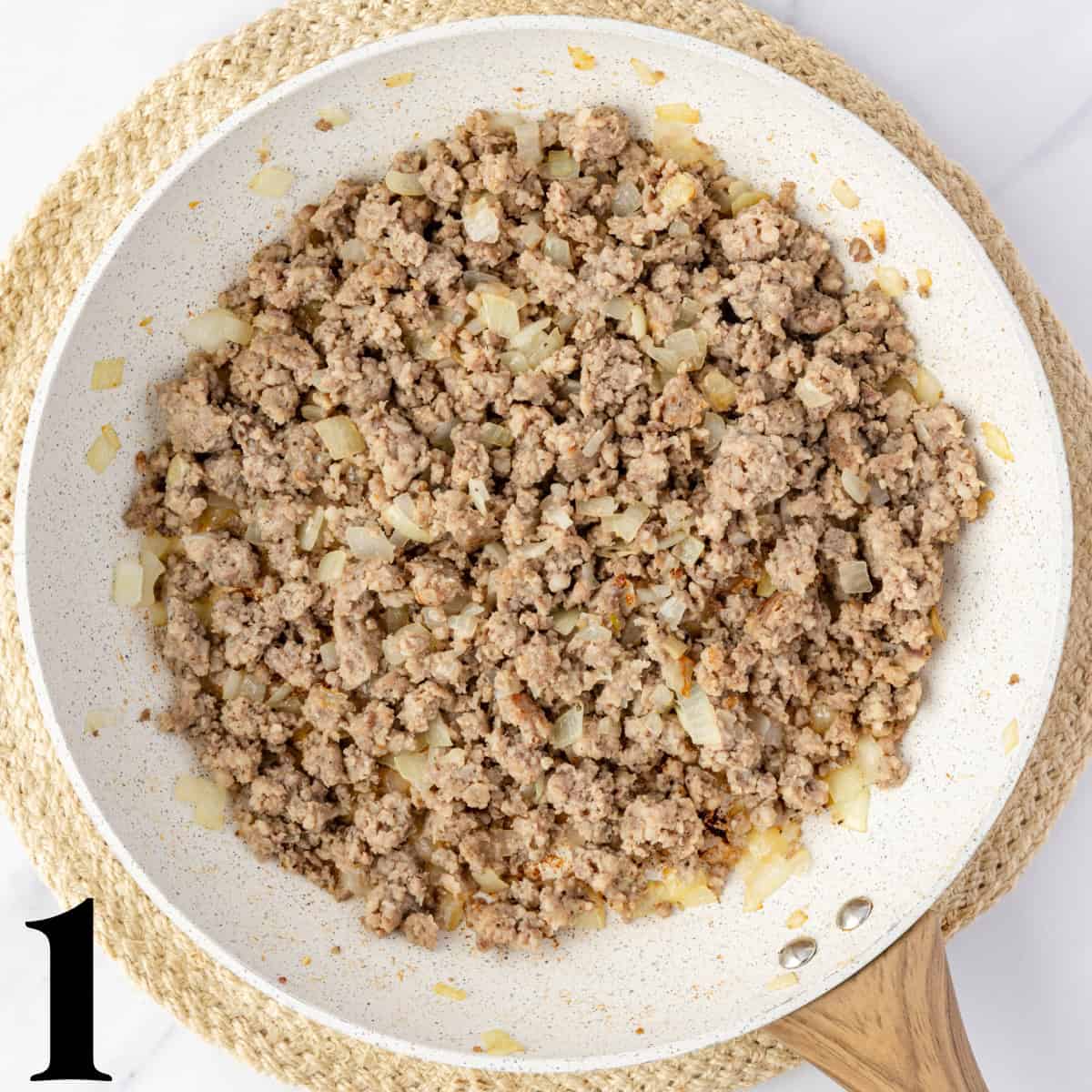 A skillet full of crumbled pork sausage.