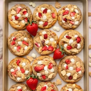 A cookie sheet full of strawberry cheesecake cookies.