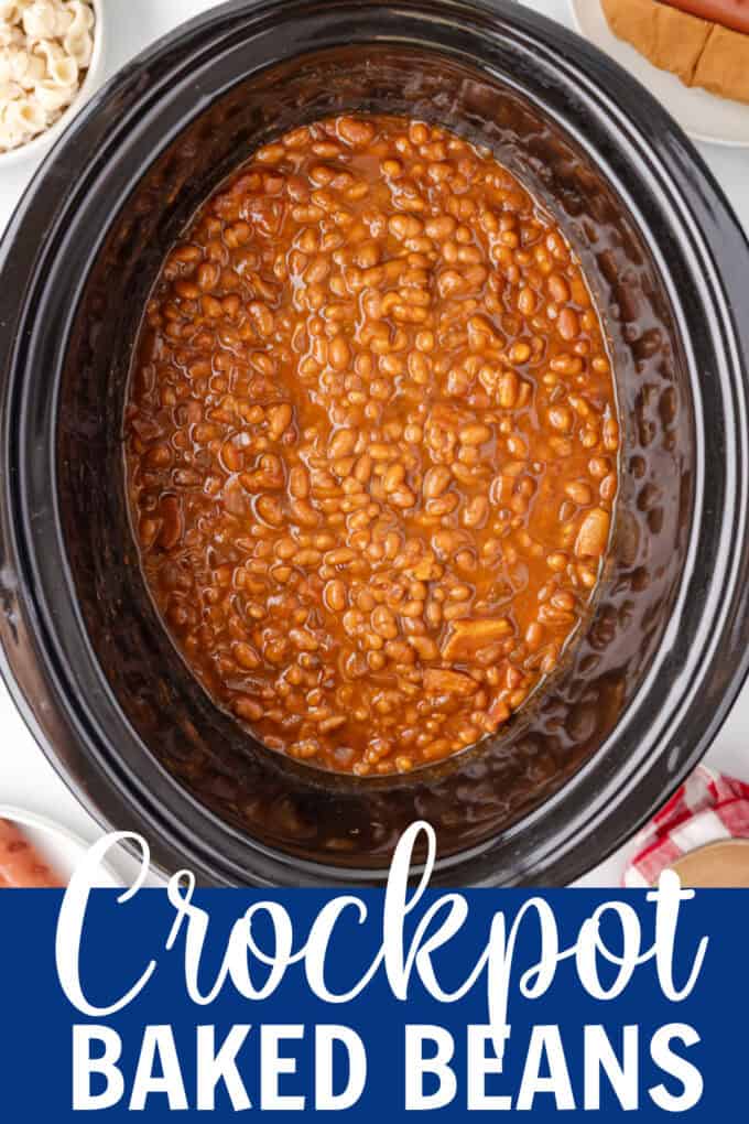 A black crockpot full of baked beans.