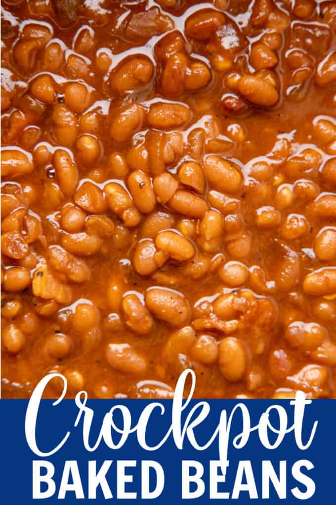 A black crockpot full of baked beans.