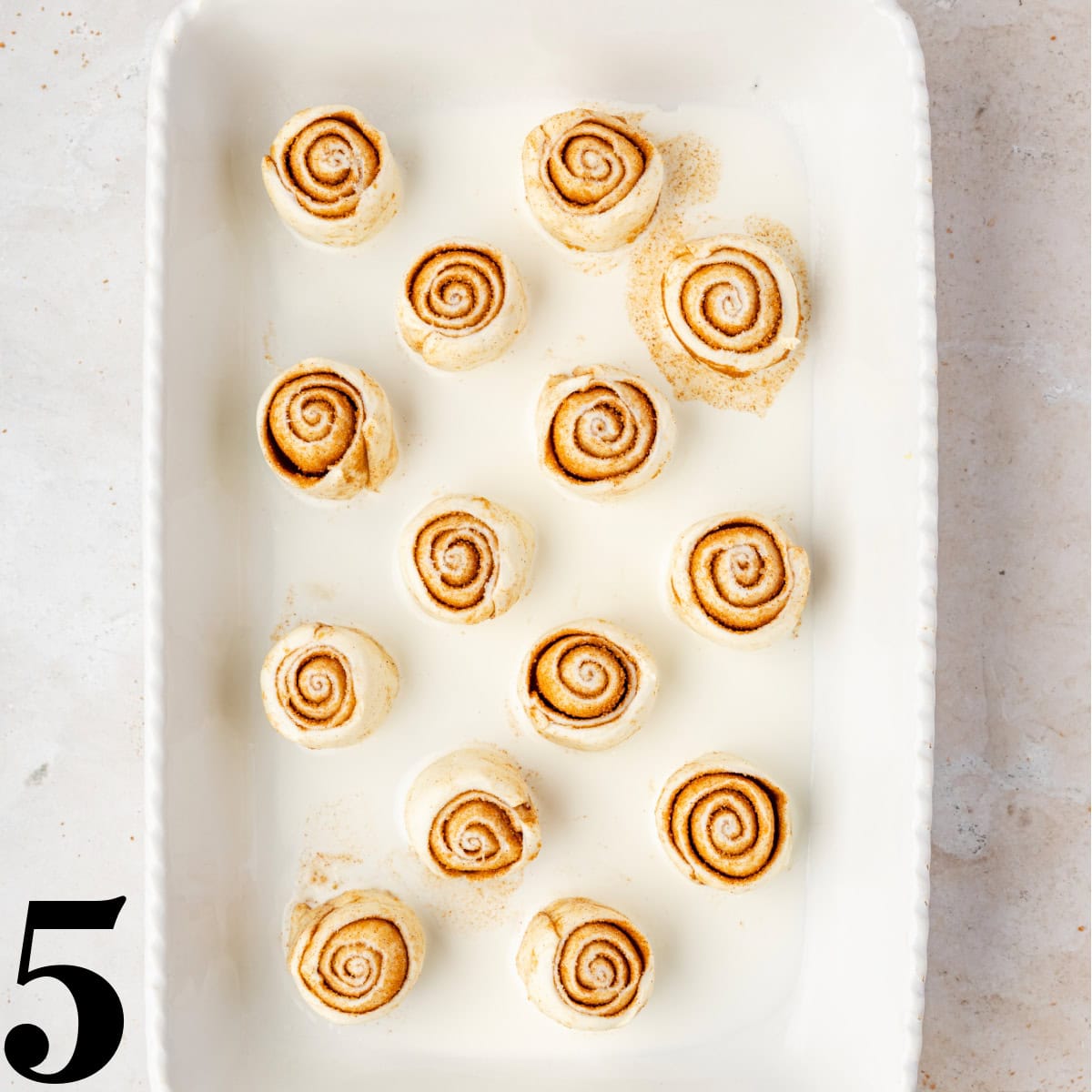 Raw cinnamon rolls in a baking pan.