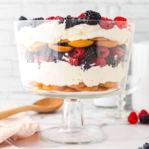 A trifle bowl full of vanilla wafers and mixd berries.