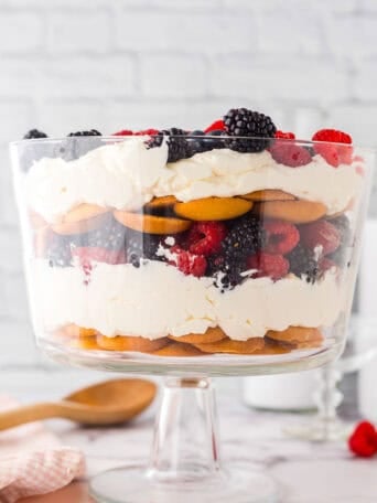 A trifle bowl full of vanilla wafers and mixd berries.