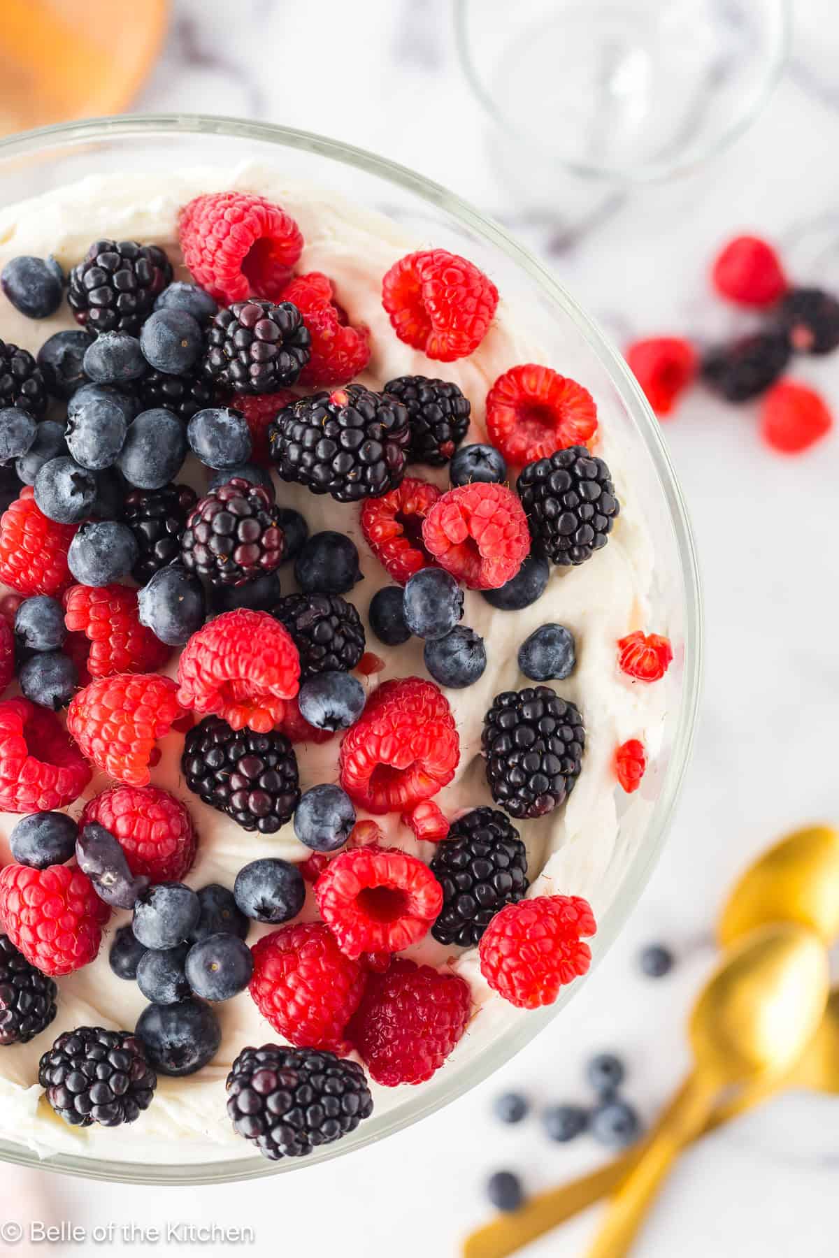 A trifle bowl full of vanilla wafers and mixd berries.