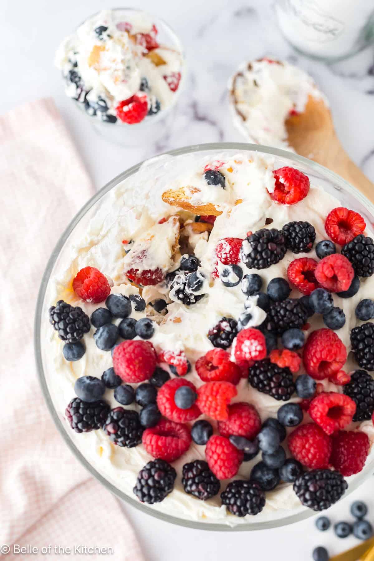 A trifle bowl full of vanilla wafers and mixd berries.