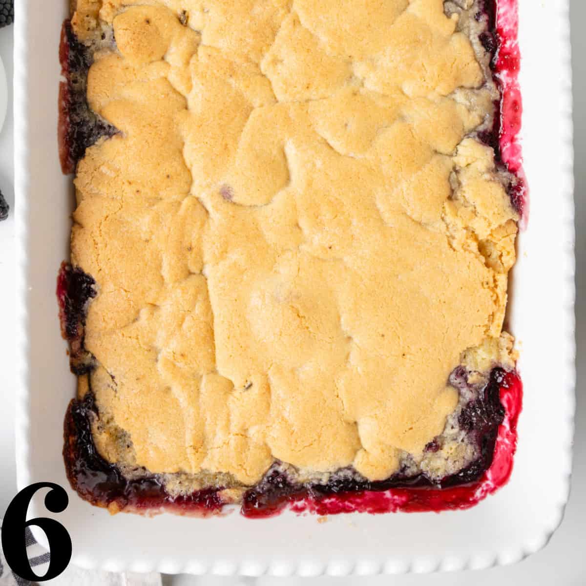 A baking dish full of baked blackberry cobbler.