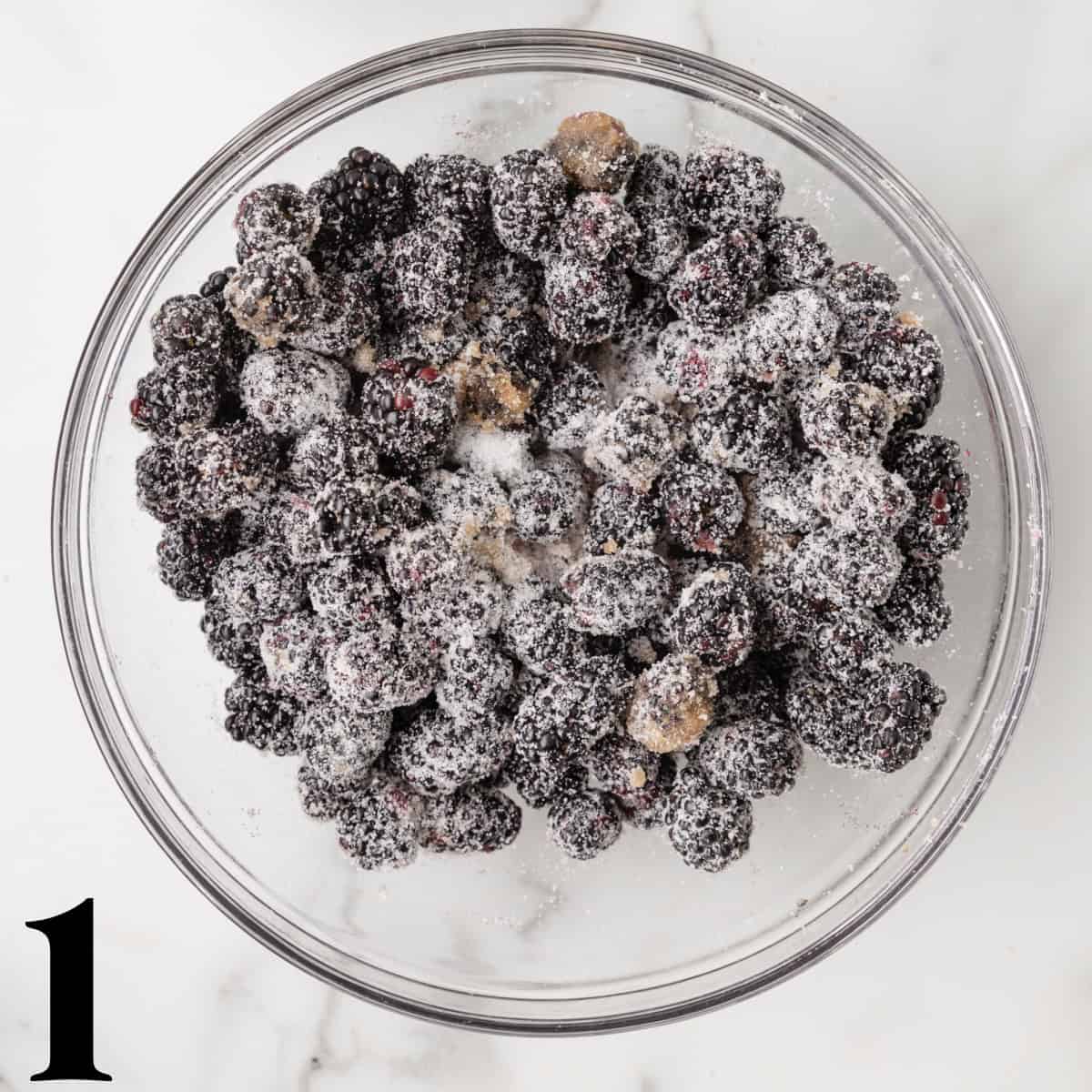 A glass bowl of sugar coated blackberries.