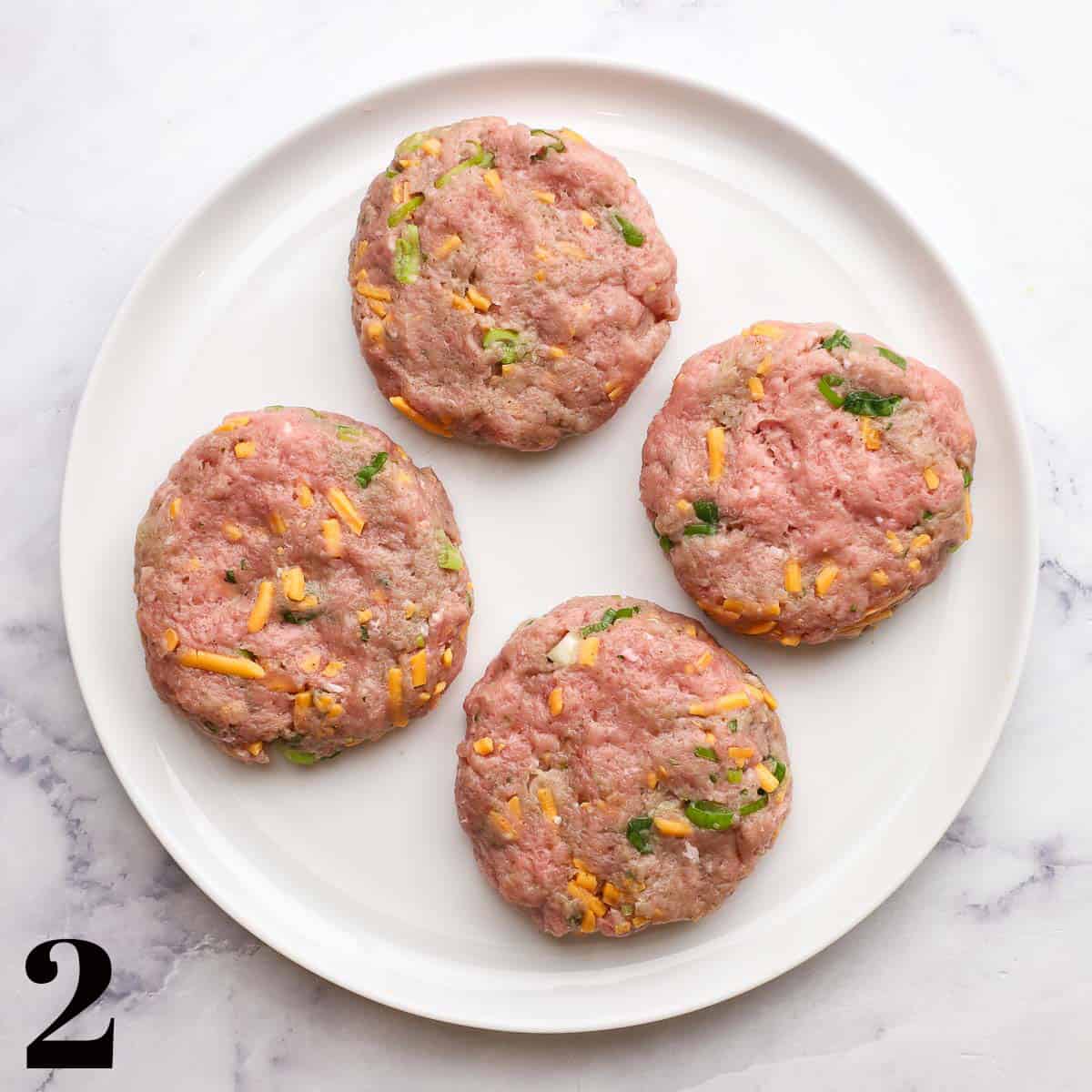 Turkey burger patties on a white plate.