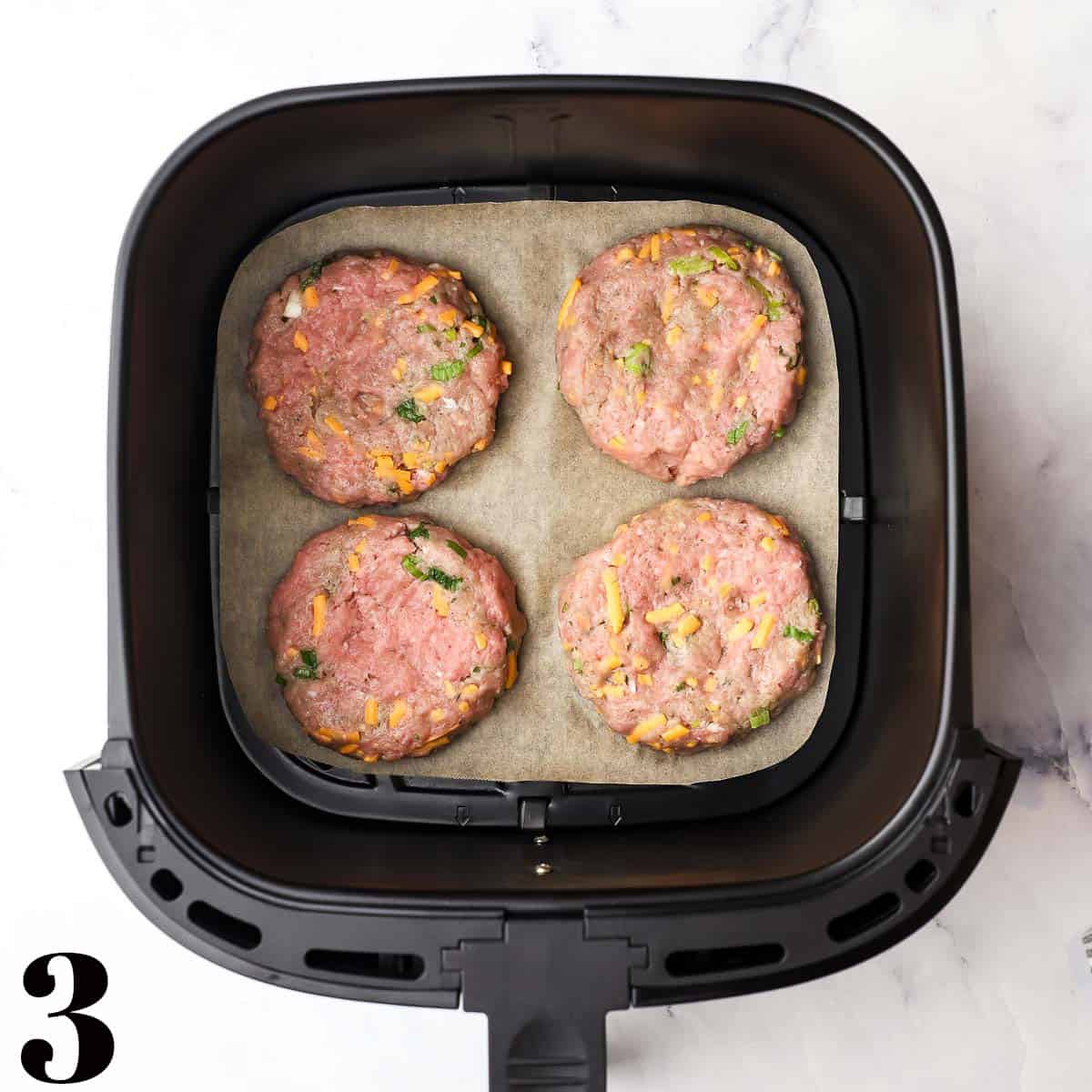 Turkey burger patties in an air fryer.