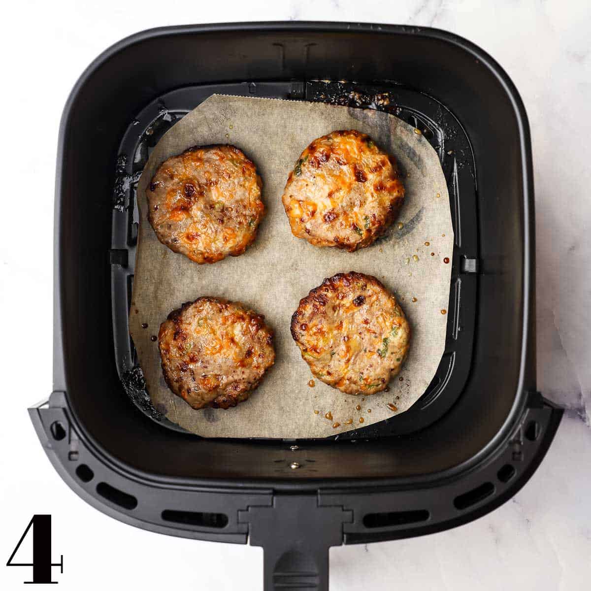 Cooked turkey burger patties in an air fryer.