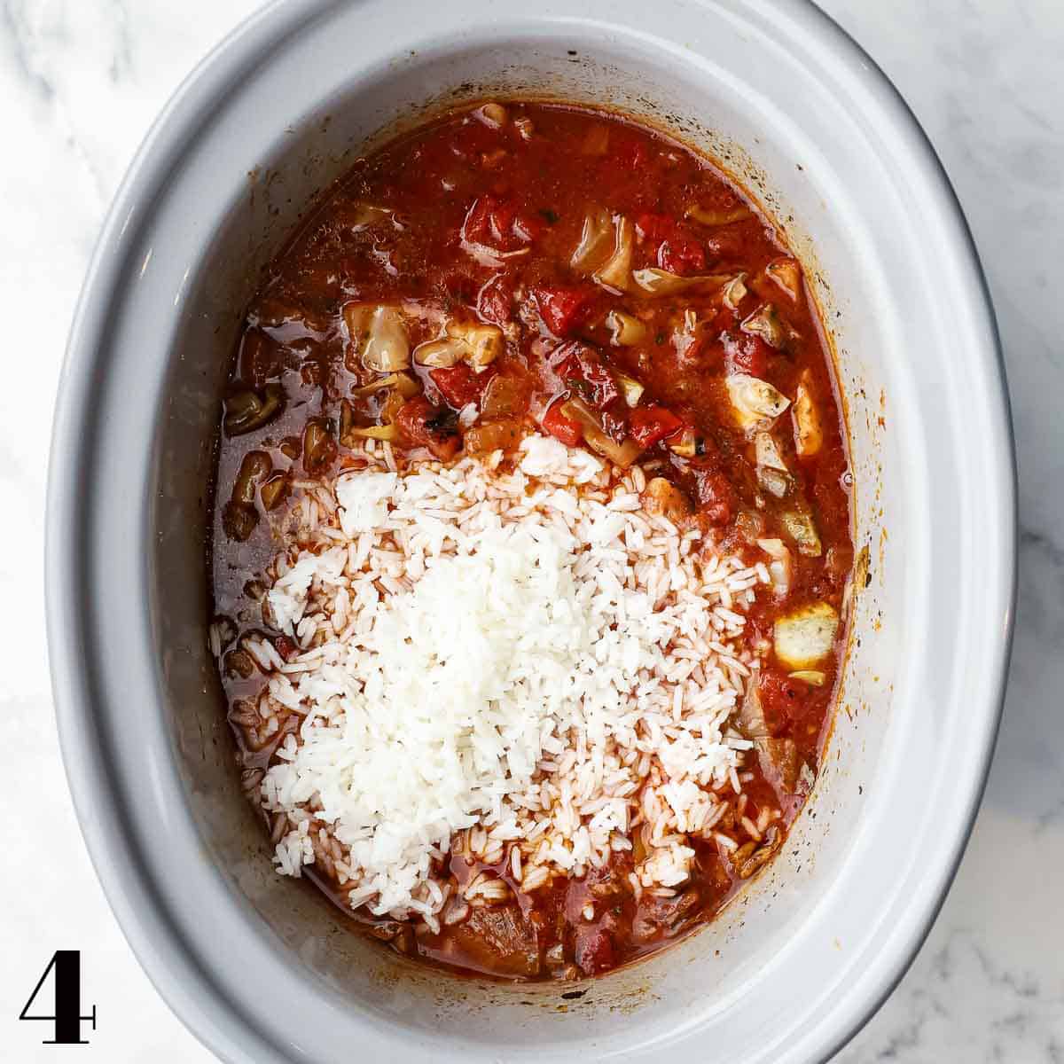 A crockpot full of cabbage roll soup with cooked rice on top.