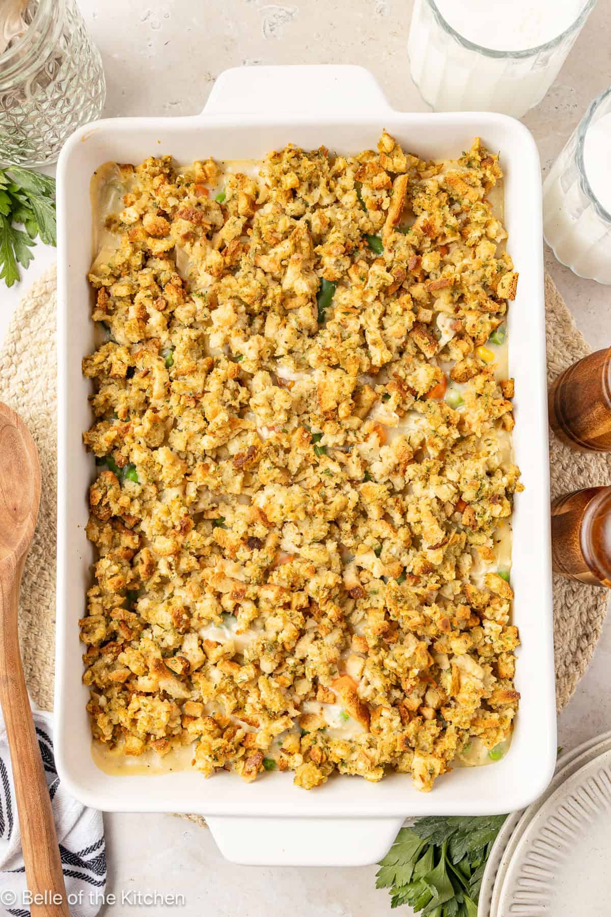 A white baking dish with chicken casserole topped with stuffing inside.