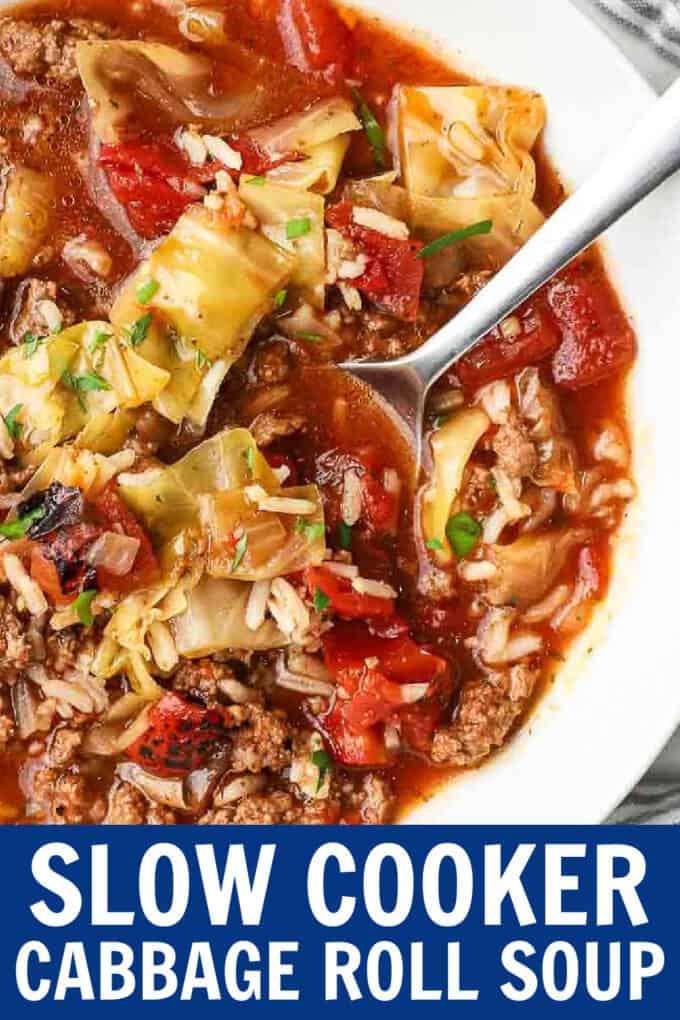A spoon scooping cabbage roll soup from a white bowl.