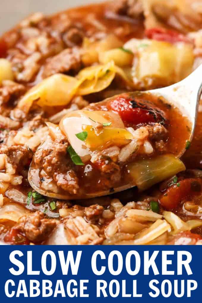 A spoon scooping cabbage roll soup from a white bowl.