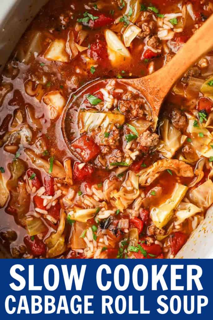 A wooden spoon scooping up cabbage roll soup from a crockpot.