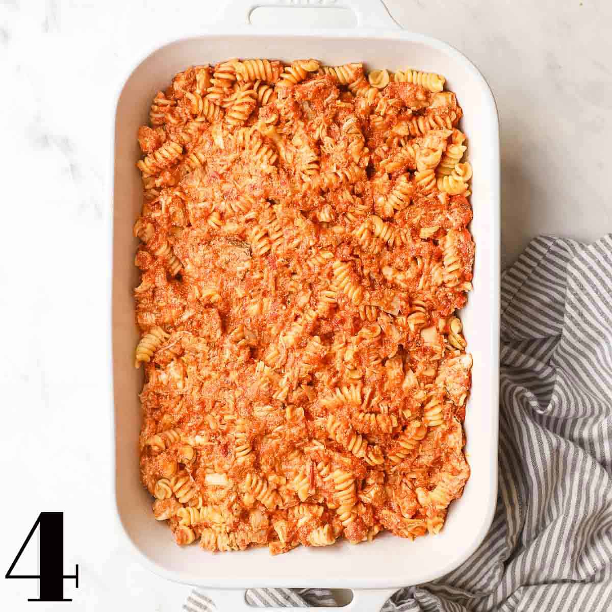 A white baking dish full of pasta and sauce.