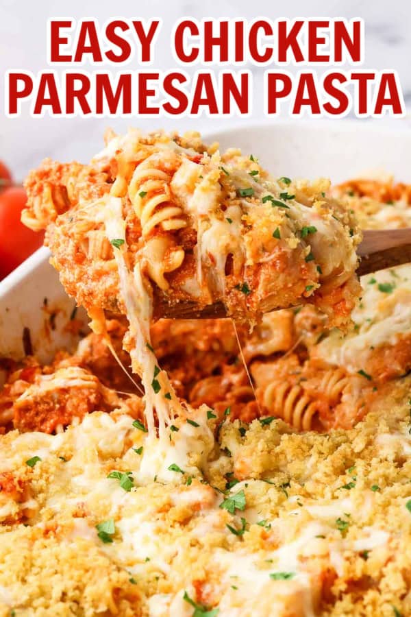 A baking dish full of chicken parmesan pasta with a wooden spoon dipping some out.