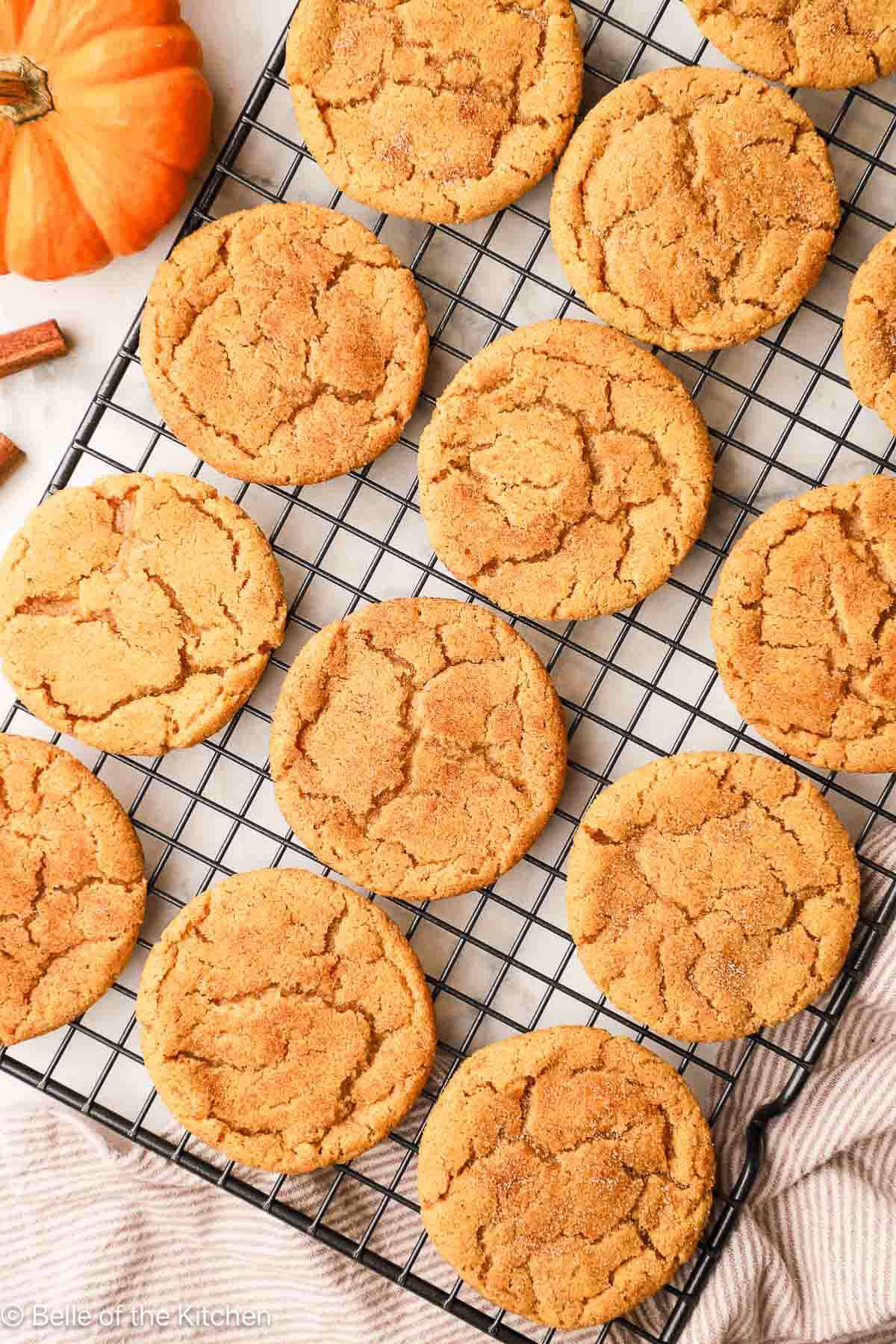 Pumpkin snickerdoodle cookies on a wire rack.
