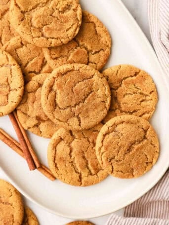 A white platter full of pumpkin snickerdoodle cookies.