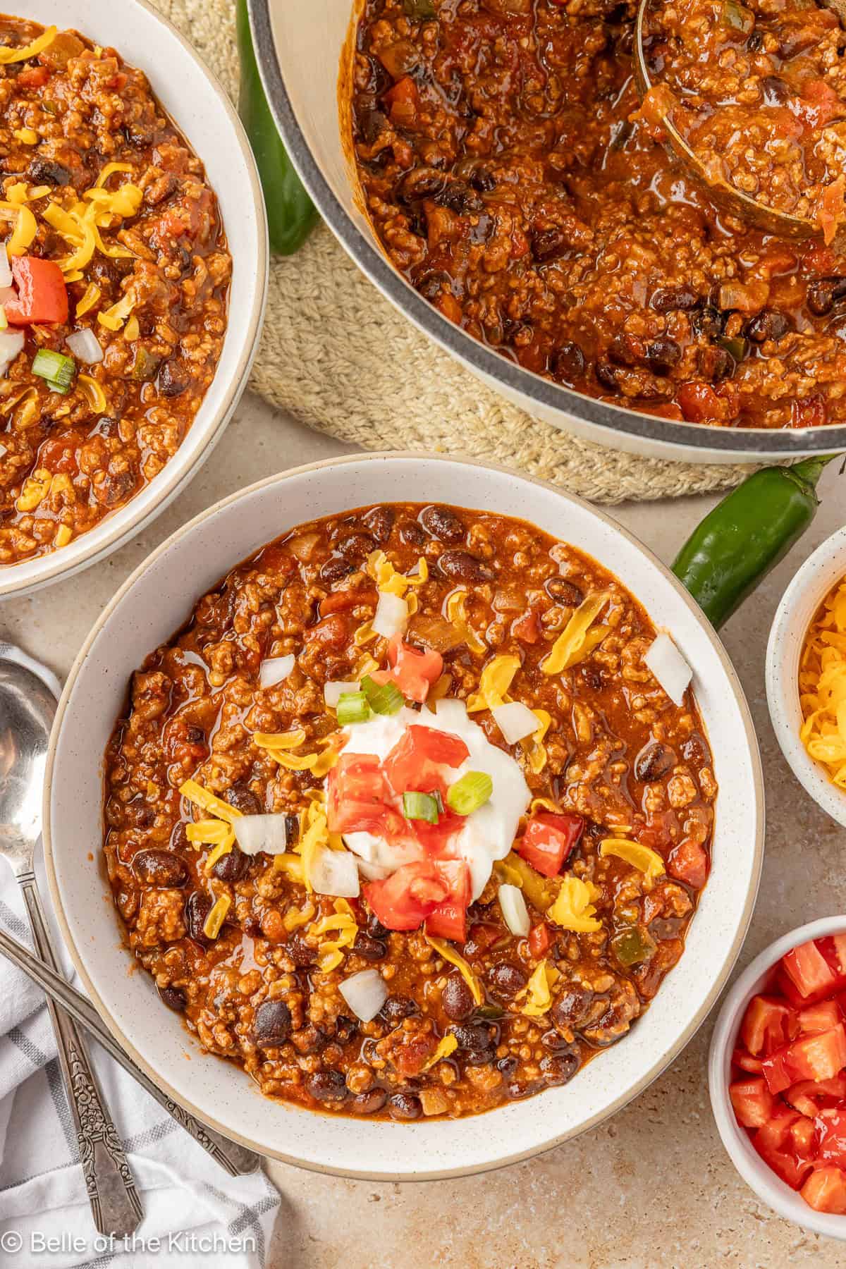 Bowls of chili next to large dutch oven.